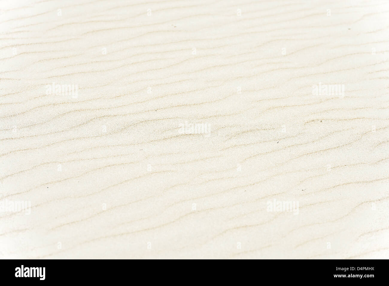 Vista ravvicinata di morbida sabbia spiaggia luce in colori beige e marrone con dolci onde. Sfondi astratti e sfondi. Detaile Foto Stock