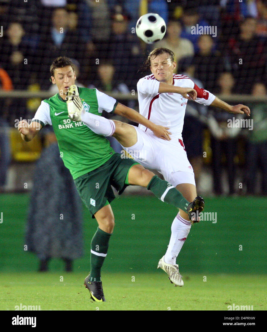 Aktobe?s Anton Chichulin (R) combatte per la palla con Brema?s Mesut Oezil durante la partita di ritorno della UEFA Europa League playoff FK Aktobe vs Bundesliga tedesca club Werder Bremen a Tsentralniy stadium (Central stadium) in Aktobe, Kazakistan, 27 agosto 2009. Foto: FRISO GENTSCH Foto Stock