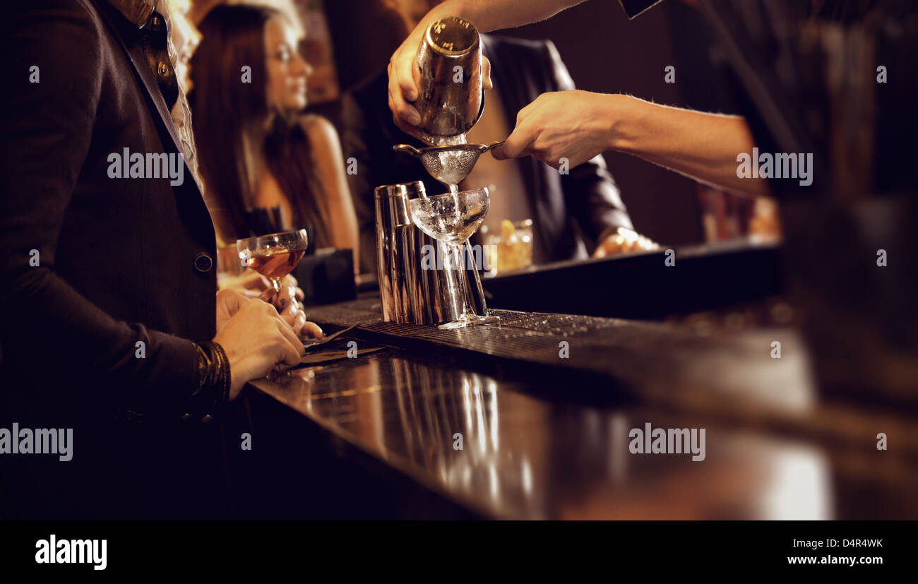 Barista usando un agitatore e versando il vino nel bicchiere di vino Foto Stock