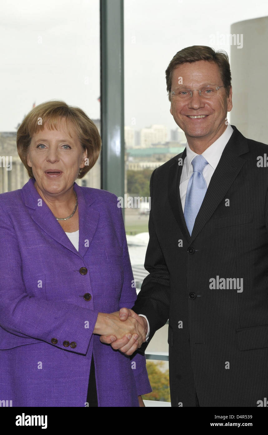 Angela Merkel, il Cancelliere tedesco e leader del conservatore cristiano democratico partito Unione (CDU) e Guido Westerwelle, leader della pro-business Liberi Democratici (FDP) agitare le mani alla cancelleria a Berlino, Germania, 28 settembre 2009. Merkel i conservatori del giurato il lunedì per sigillare una coalizione trattativa, compresi i tagli fiscali con il pro-business Liberi Democratici (FDP) entro un mon Foto Stock
