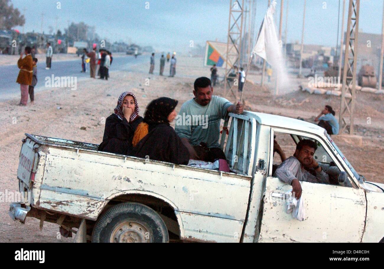 I civili iracheni stanno alzando una bandiera bianca e aspettare la fine delle battaglie, il 4 aprile 2003, circa 15 chilometri a sud di Baghdad. Foto Stock