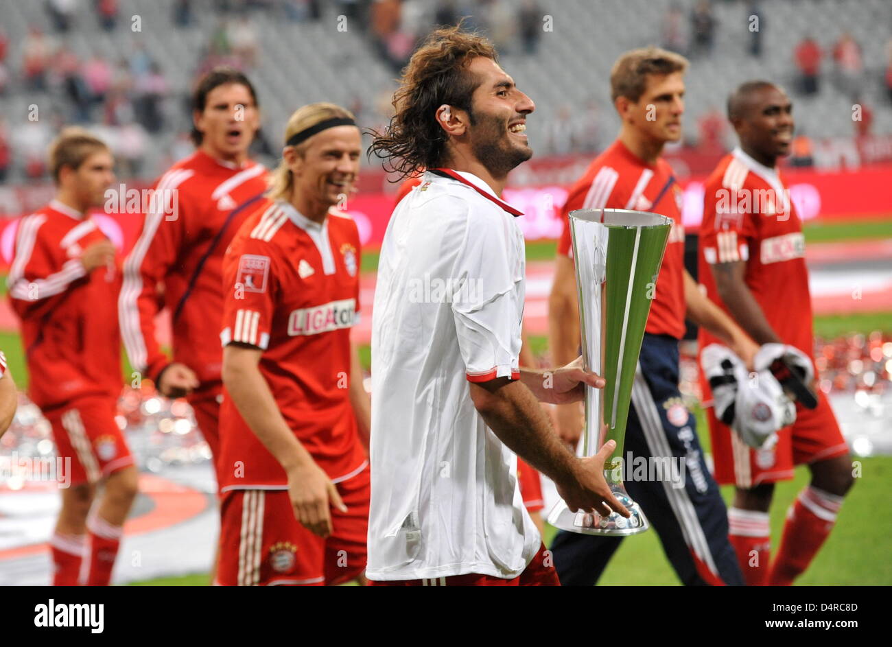 Il Bayern Monaco di Baviera?s Hamit Altintop (C) porta il trofeo per la vittoria della Audi finali di Coppa partita FC Bayern Monaco vs manchester united a stadio Allianz Arena di Monaco di Baviera, Germania, il 30 luglio 2009. Il Bayern Monaco ha vinto la partita 7-6 p.s.o. Foto: Tobias Hase Foto Stock