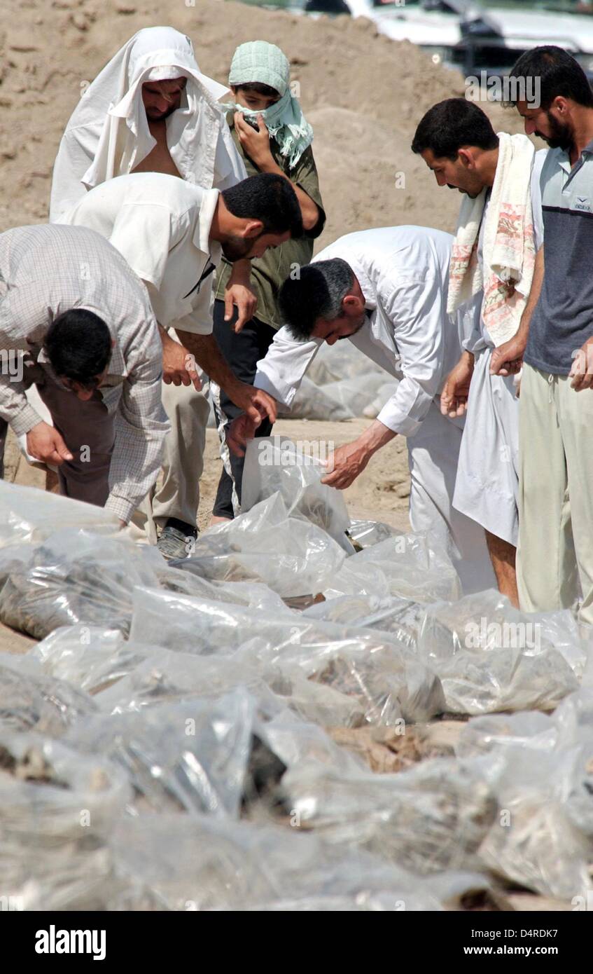 Musulmani sciiti ispezionare i sacchetti di plastica con resti mortali di soldati e civili che sono stati trovati in una tomba di massa, il 14 maggio 2003 nei pressi di El Kathonia, circa 80km a sud di Baghdad. Foto Stock