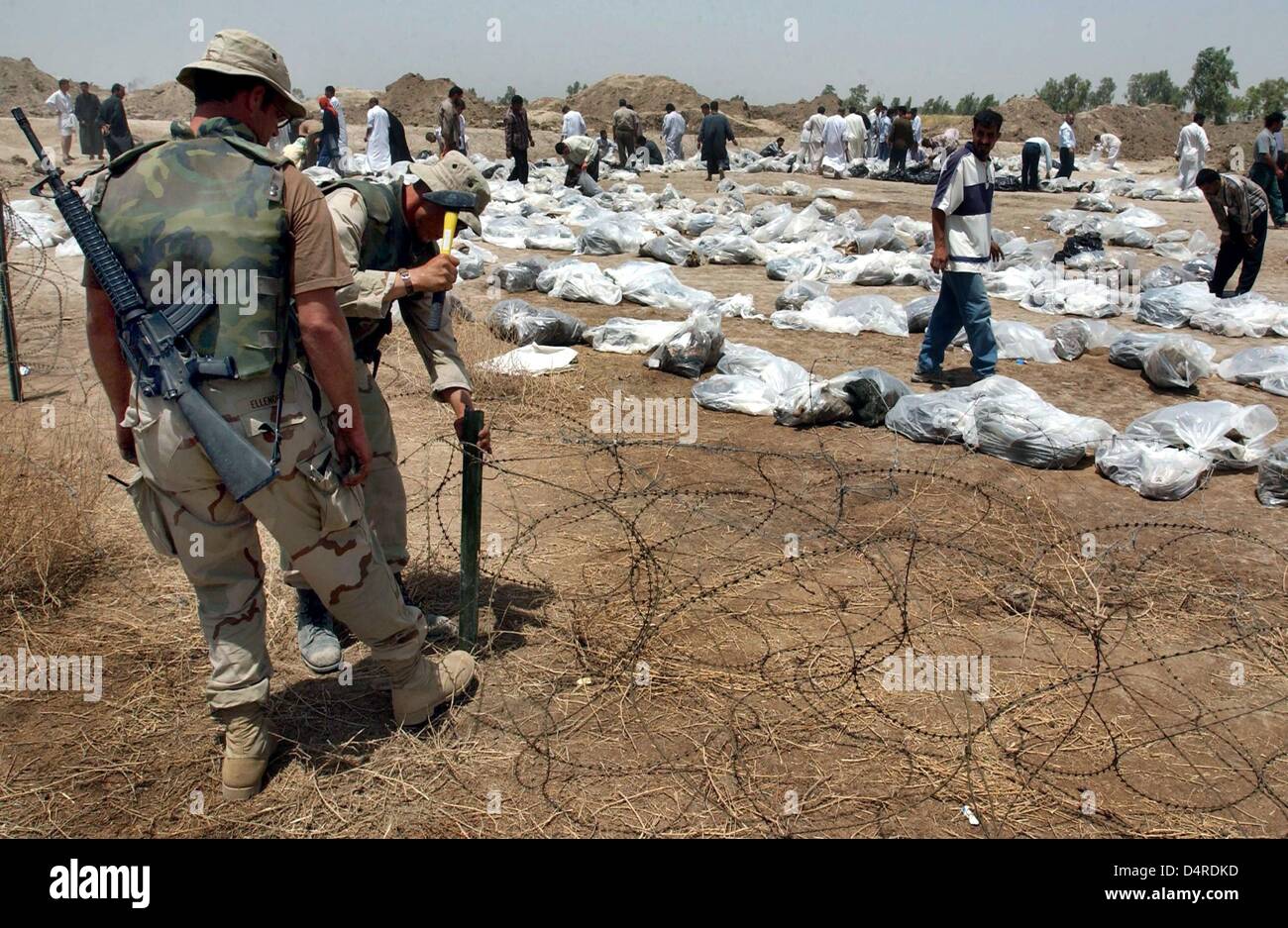I soldati Usa recinto una fossa comune con sacchetti di plastica contenenti resti mortali di soldati e civili, il 16 maggio 2003 in Mahaweel, a circa 100km a sud di Baghdad. Foto Stock