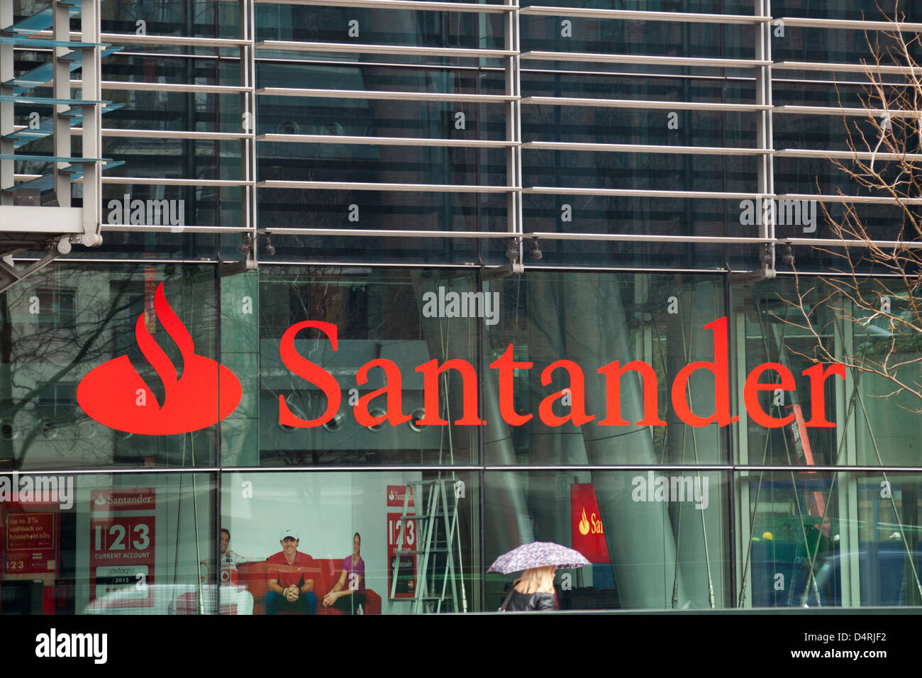 Una donna cammina davanti al Santander UK Capo Ufficio presso il Regent's Place, Londra. Foto Stock