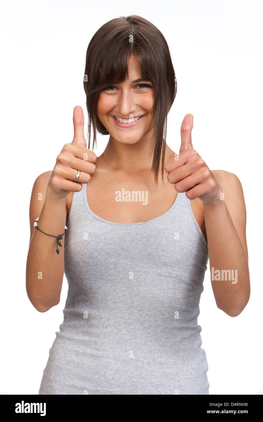 Intaglio sorridente giovane donna con capelli lunghi marrone indossando un serbatoio grigio top entrambe le mani pollice in alto Foto Stock