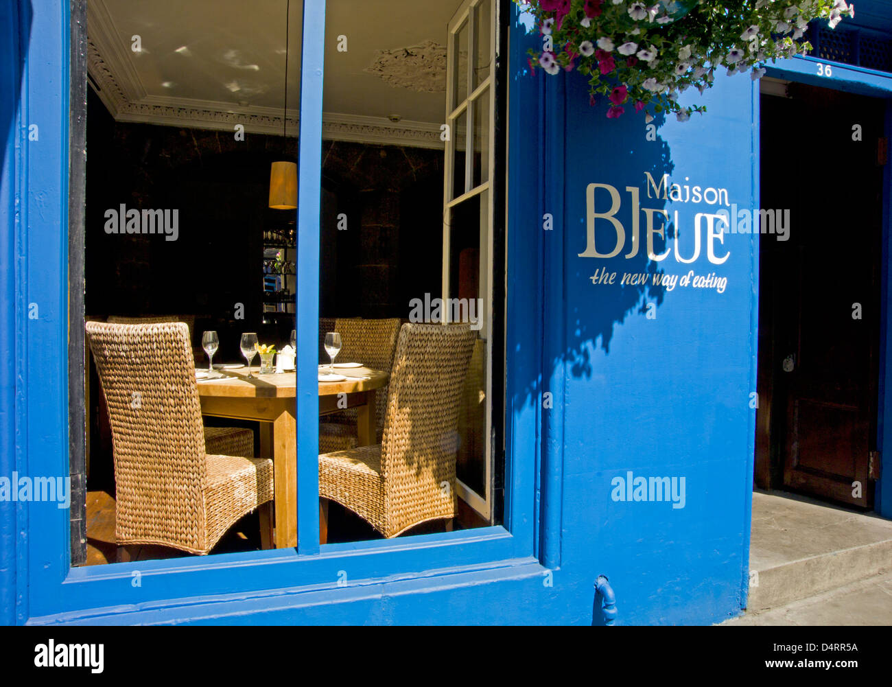 La maison bleue ristorante e appeso basket a Victoria Street con vista delle tabelle nella finestra Foto Stock