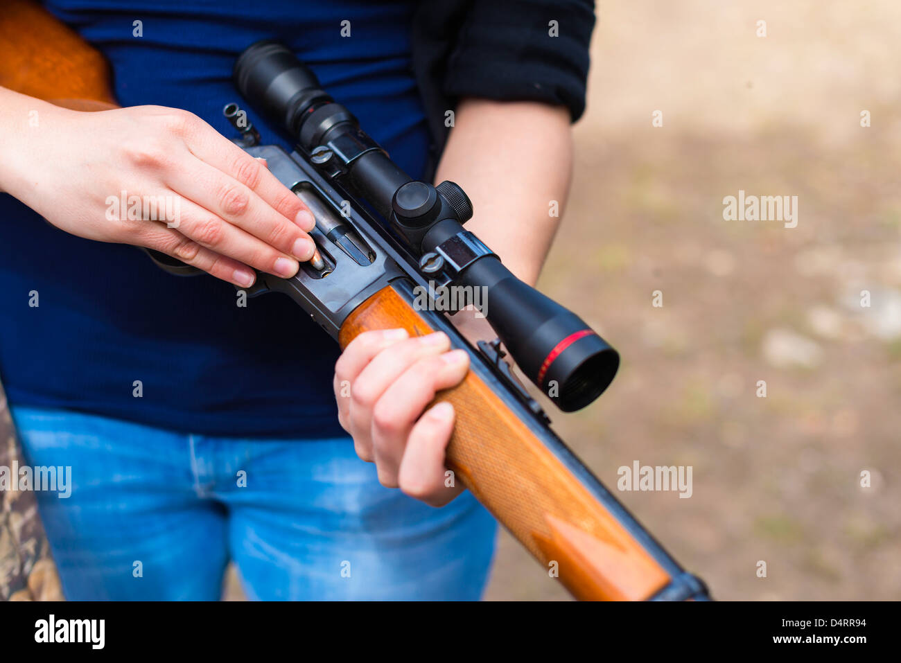 Giovane donna il caricamento di un fucile da caccia con cartucce di munizioni, femmina 19 Caucasian Foto Stock