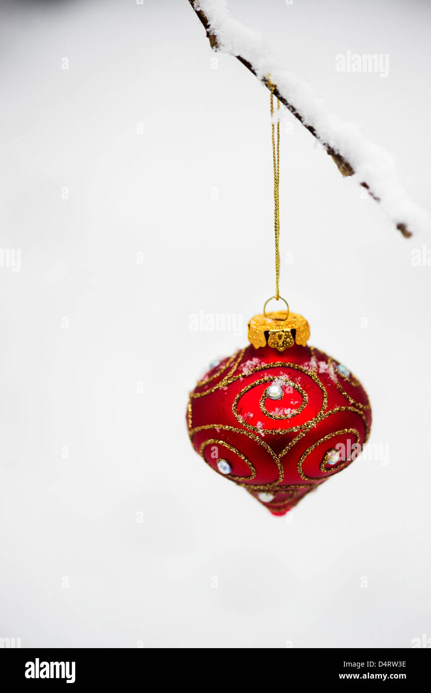 Albero di Natale decorazioni / baubles appesi a un ramo di albero nella neve Foto Stock