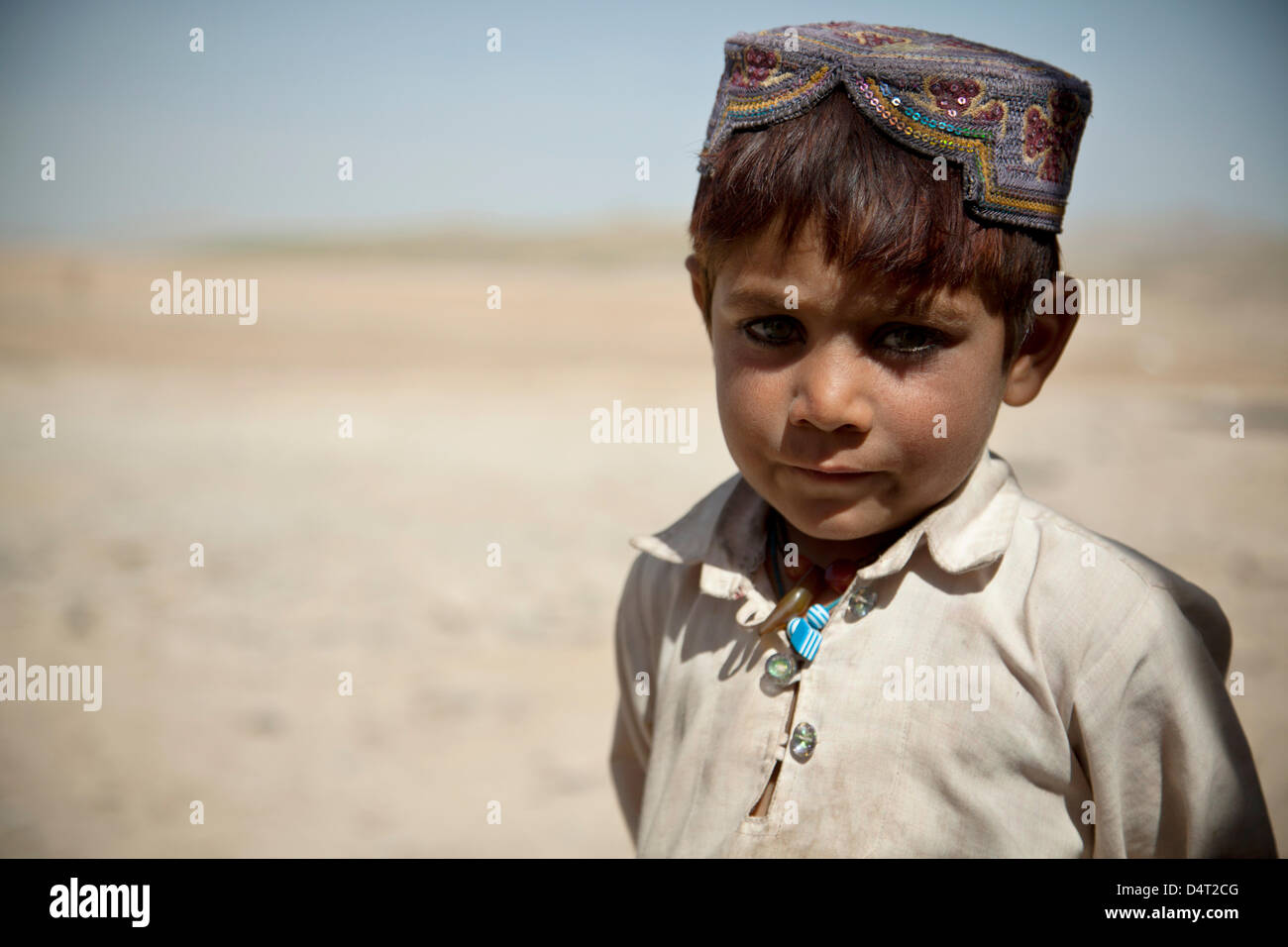 Un giovane ragazzo afghano orologi Esercito Nazionale delle forze speciali forniscono la protezione per un governatore distrettuale Marzo 17, 2013 nella provincia di Helmand, Afghanistan. Foto Stock