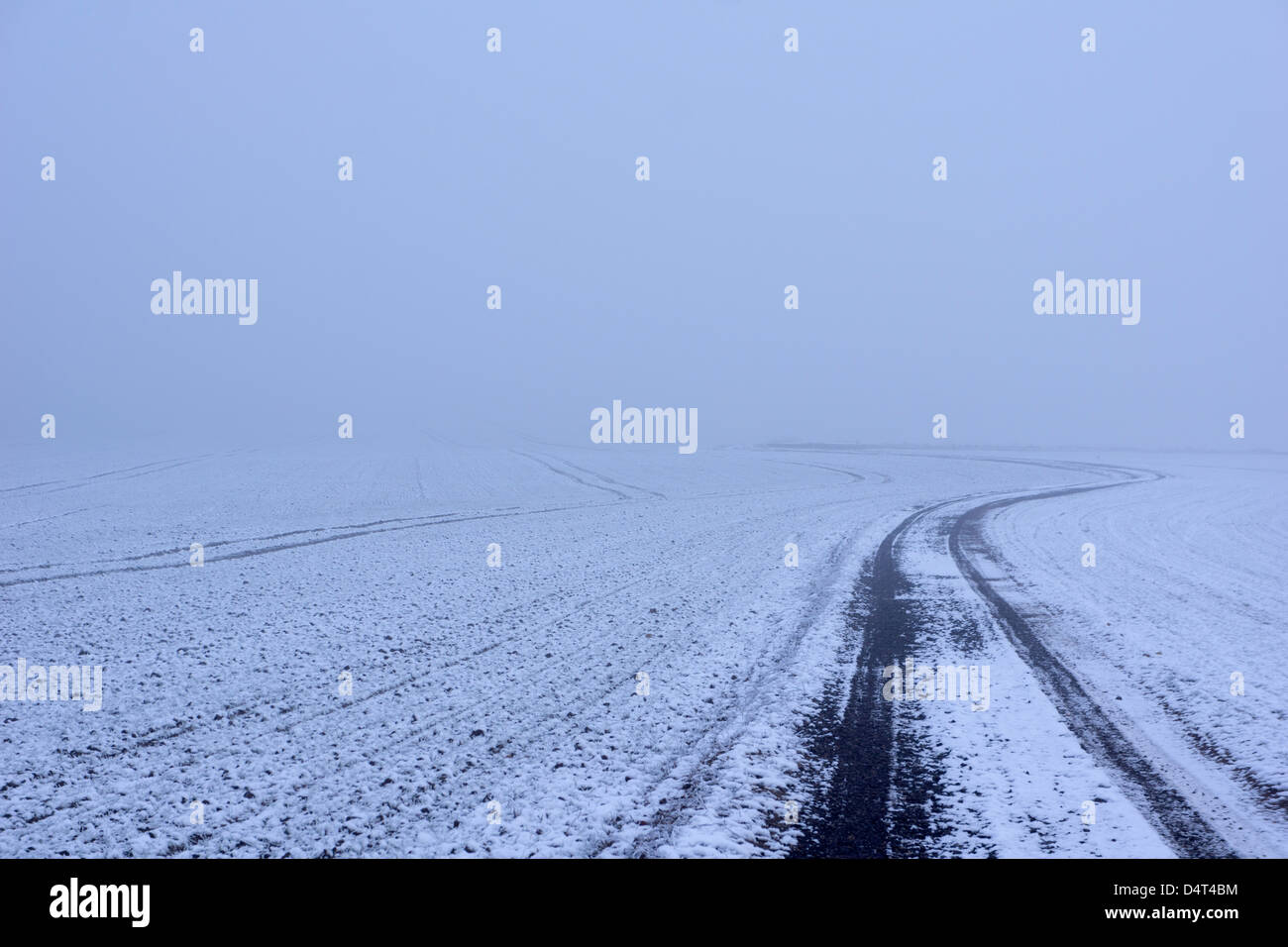 Scene invernali intorno a Doncaster con una casa di pietra ricoperta di neve, una persona che cammina attraverso un sentiero boschivo ghiacciato e impronte attraverso il fiel innevato Foto Stock