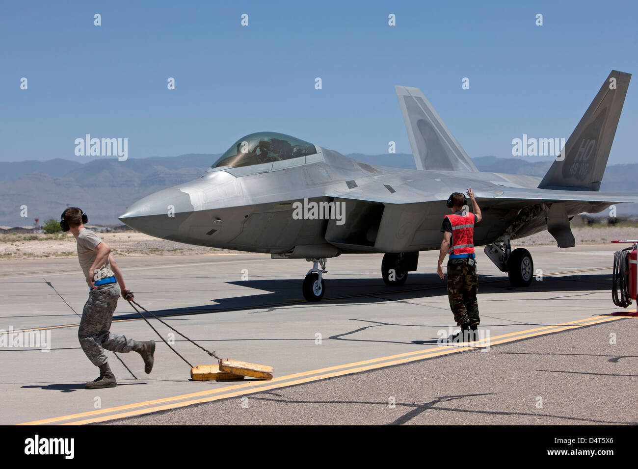 Equipaggi di manutenzione eseguire controlli preflight con F-22 rapaci. Foto Stock