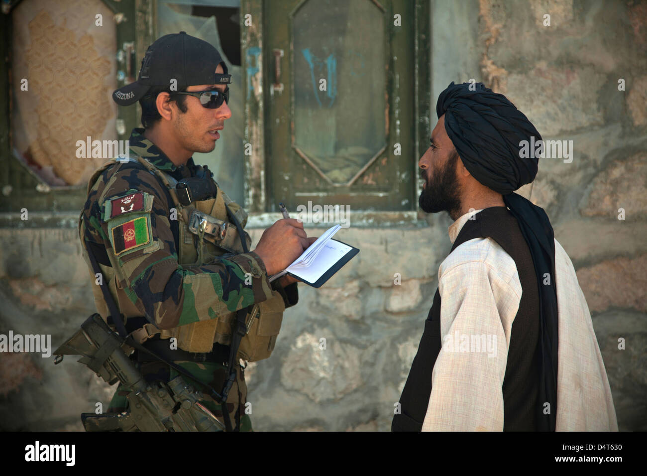 Un esercito nazionale afghano delle forze speciali parla con un afghano di Polizia Locale candidato Marzo 16, 2013 nella provincia di Helmand, Afghanistan. Foto Stock
