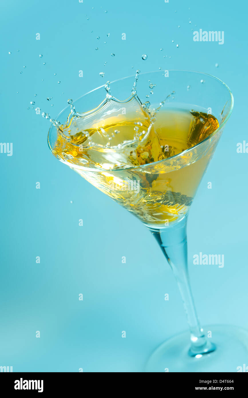 Spruzzi di oliva su un bicchiere di martini Foto Stock