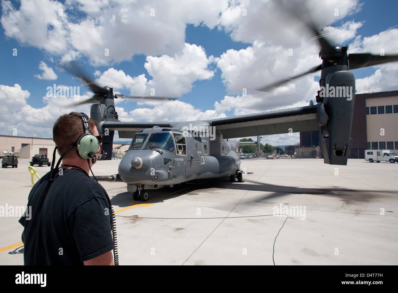 Un capo equipaggio orologi come un CV-22 Osprey esegue controlli di preflight Foto Stock