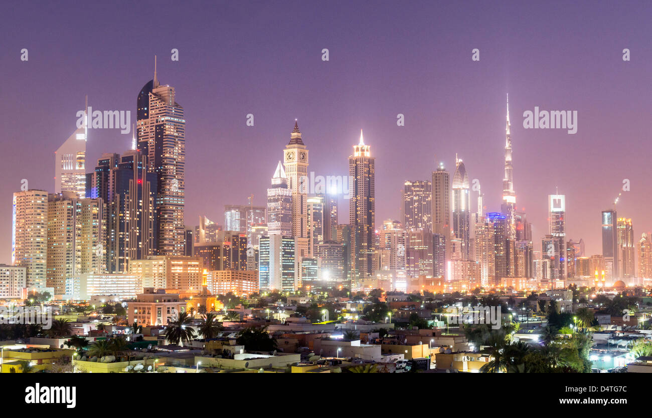 Vista notturna di fronte al vecchio quartiere Satwa verso un sistema moderno skyline di Dubai con grattacieli di Emirati Arabi Uniti Foto Stock