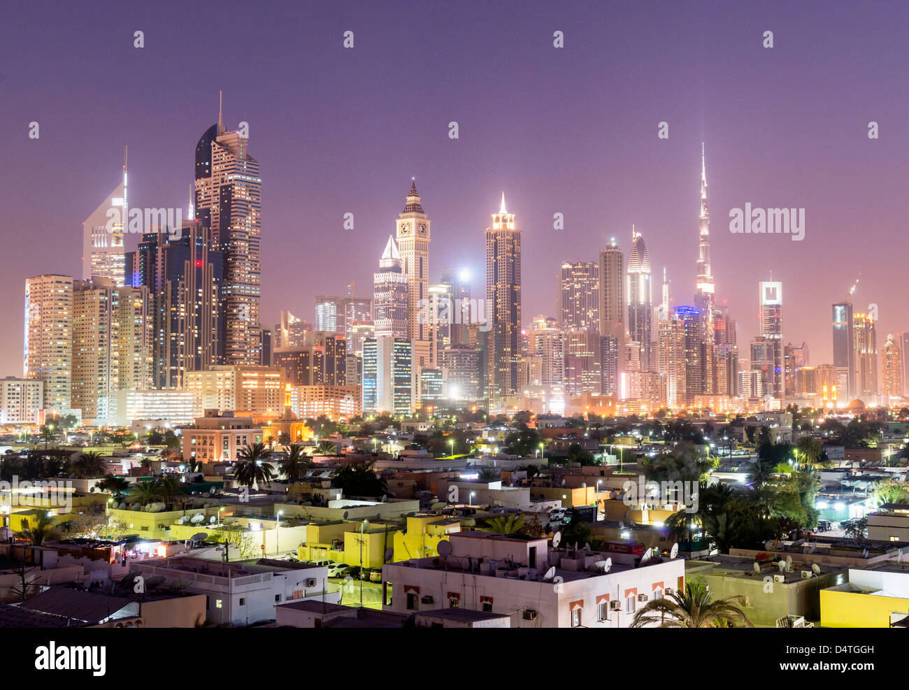 Vista notturna di fronte al vecchio quartiere Satwa verso un sistema moderno skyline di Dubai con grattacieli di Emirati Arabi Uniti Foto Stock