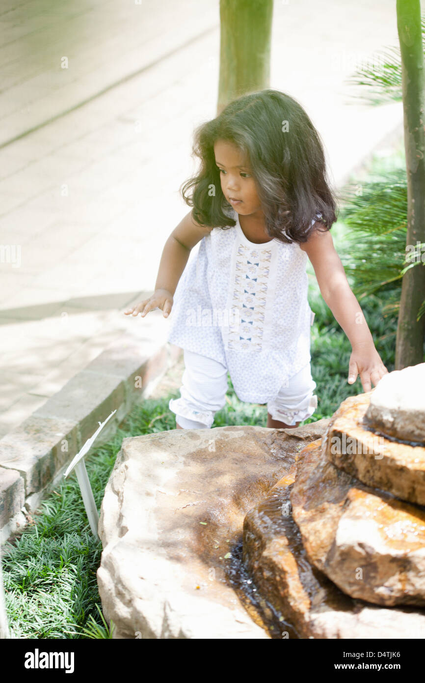 Ragazza salendo sulla fontana di pietra Foto Stock