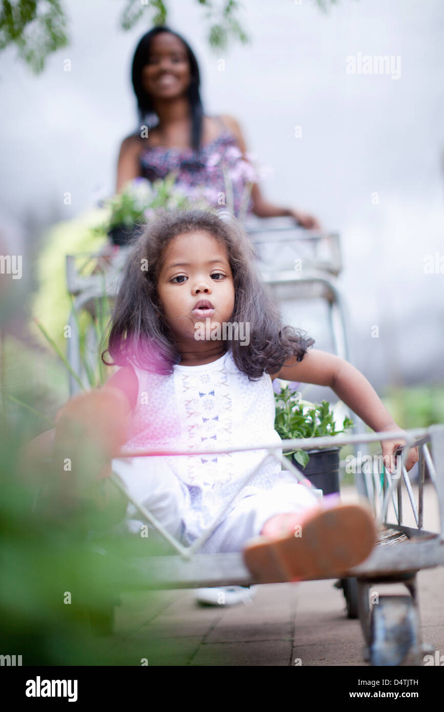 Ragazza seduta nel carrello al vivaio Foto Stock