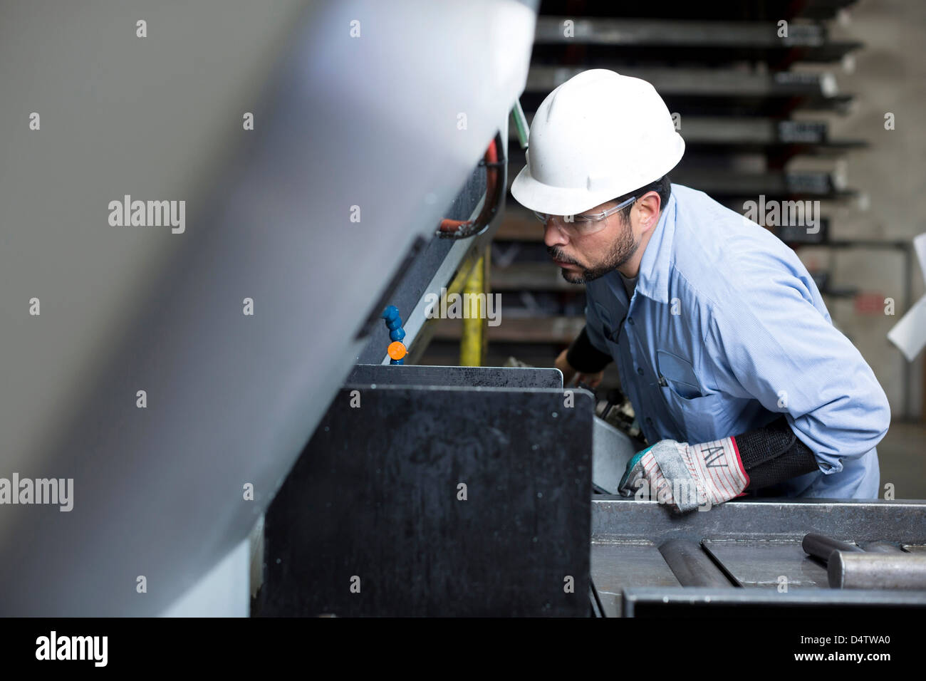 Lavoratore utilizzando macchinari di impianto in metallo Foto Stock