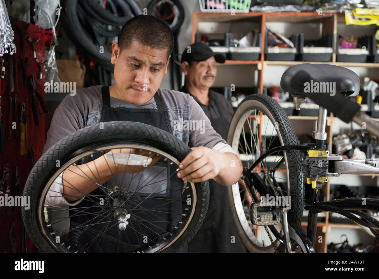 Meccanico che lavora nel negozio di biciclette Foto Stock