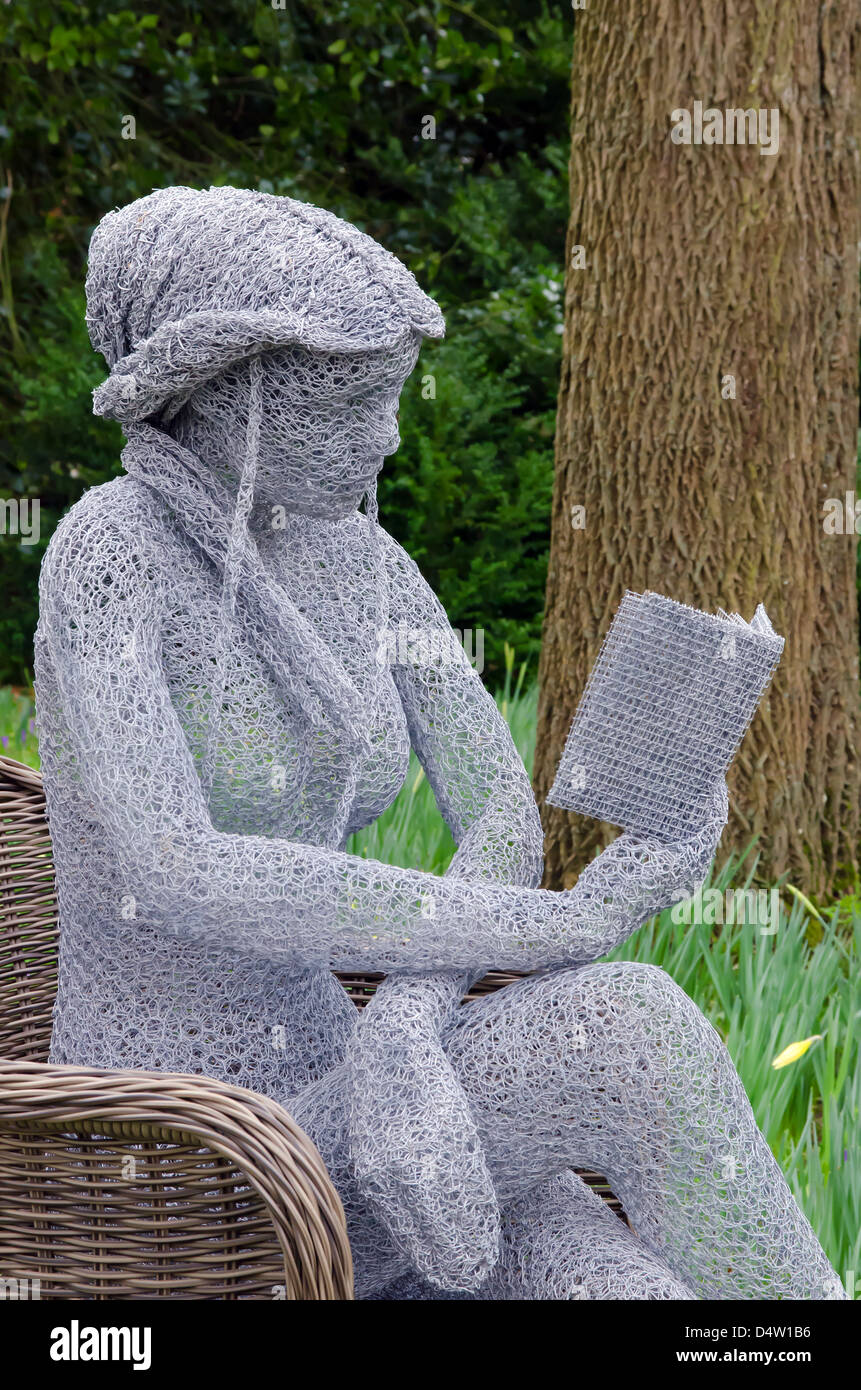 Statua della Ragazza di filo di lettura in impostazione di bosco Foto Stock
