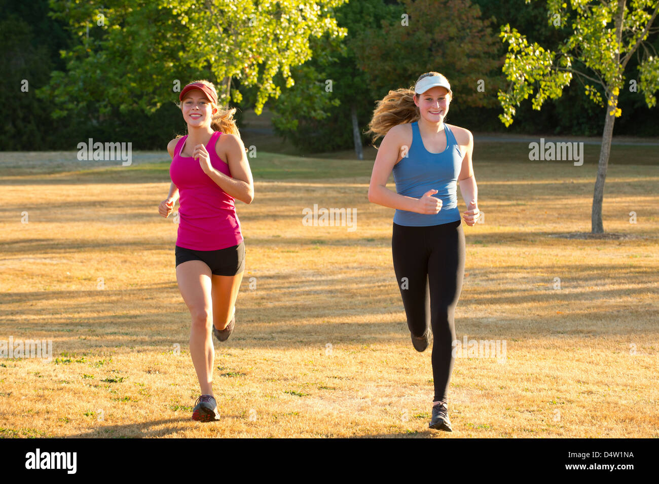 Le ragazze adolescenti correndo insieme nel campo Foto Stock