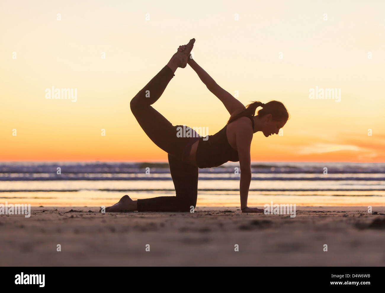 La donna a praticare yoga sulla spiaggia Foto Stock