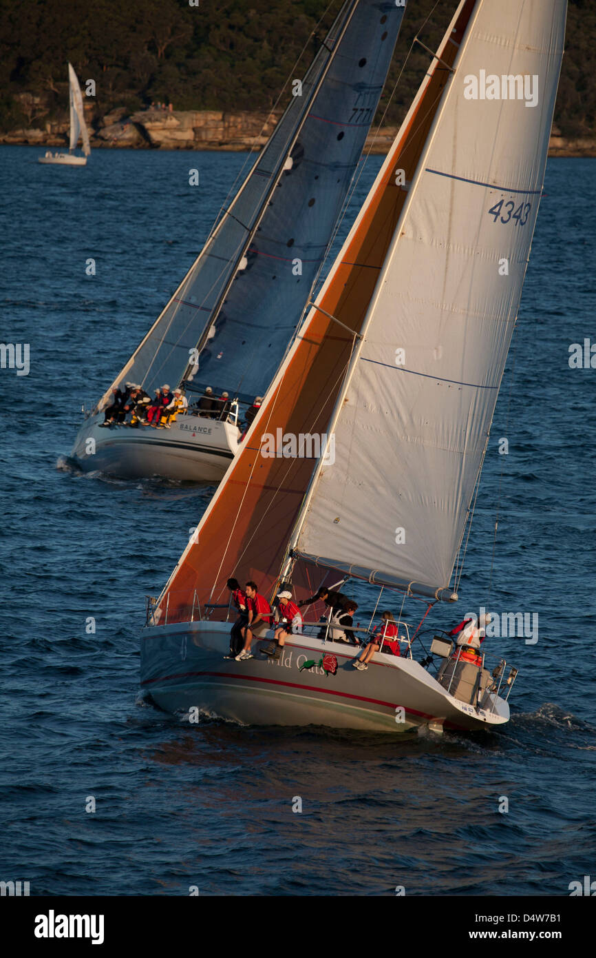 Due barche a pieno la vela passando vicino ad ogni altro sul porto di Sydney Sydney Australia Foto Stock