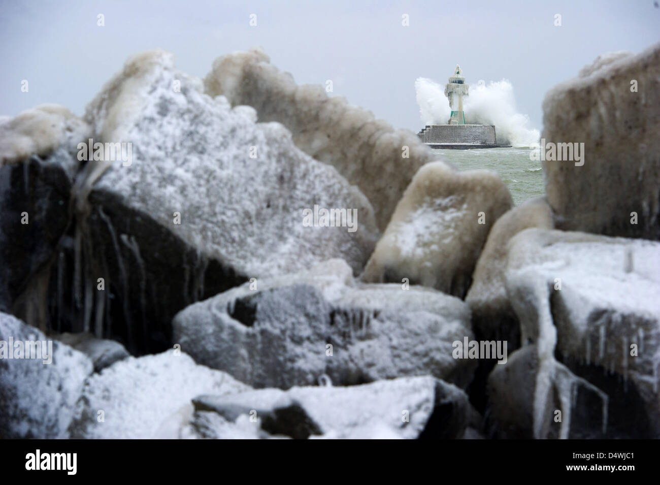 Un'onda si blocca oltre il faro sul 1.440 metri lungo frangiflutti sull isola di Ruegen in Sassnitz, Germania, 19 marzo 2013. Foto: Stefan Sauer Foto Stock