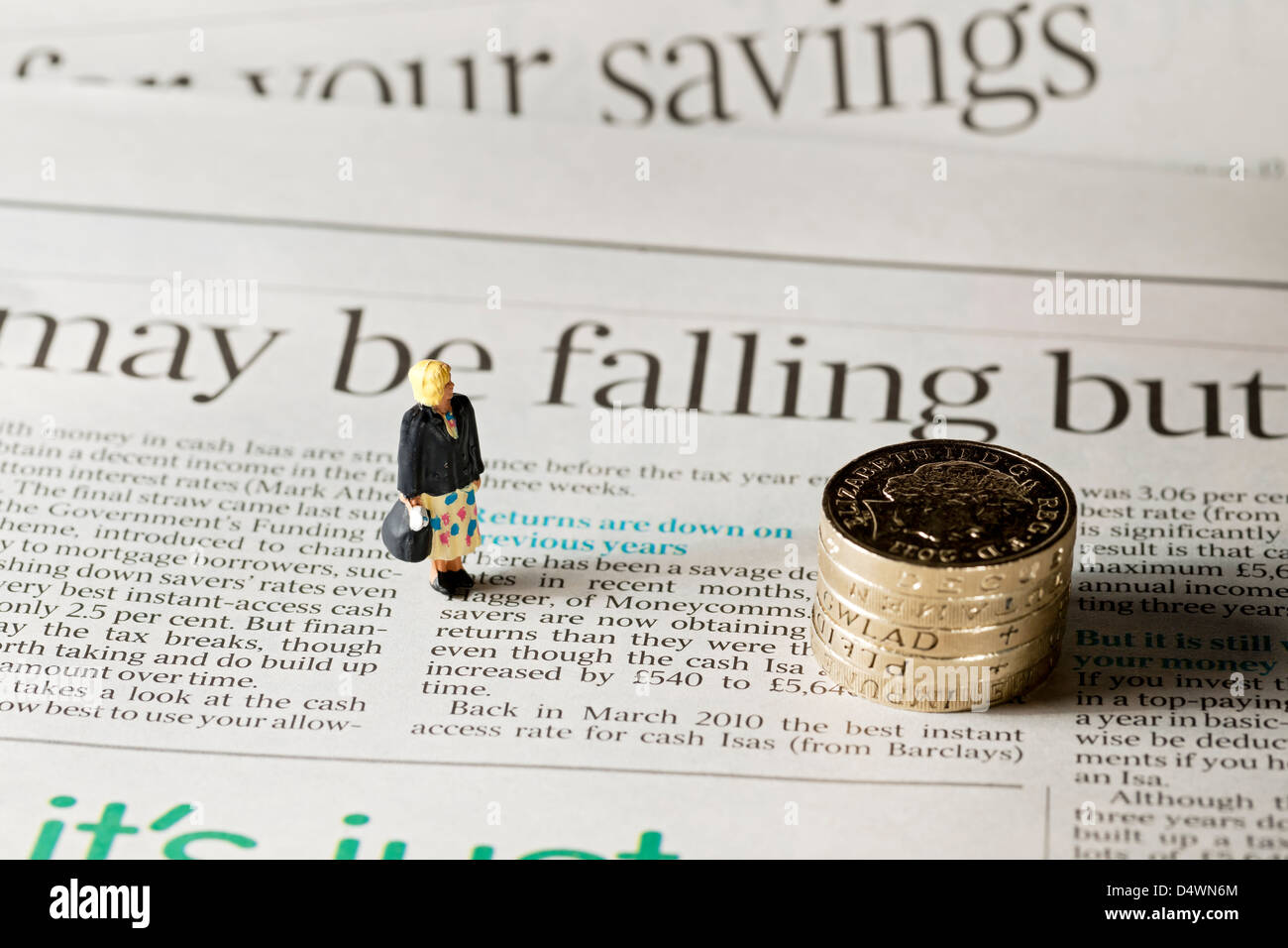 Primo piano di Toy piccola figura di una donna si trovava sulla pagina del concetto di finanza aziendale dei giornali finanziari che abbassava i tassi di interesse Foto Stock