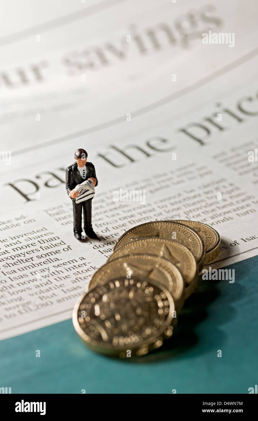 Primo piano di un giocattolo, una piccola figura di uomo d'affari si trovava accanto alle monete inglesi sulla pagina del concetto di finanza aziendale dei giornali finanziari Foto Stock