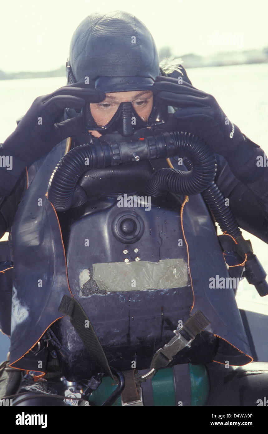 Un Navy SEAL combattere nuotatore regola la sua maschera subacquea. Foto Stock