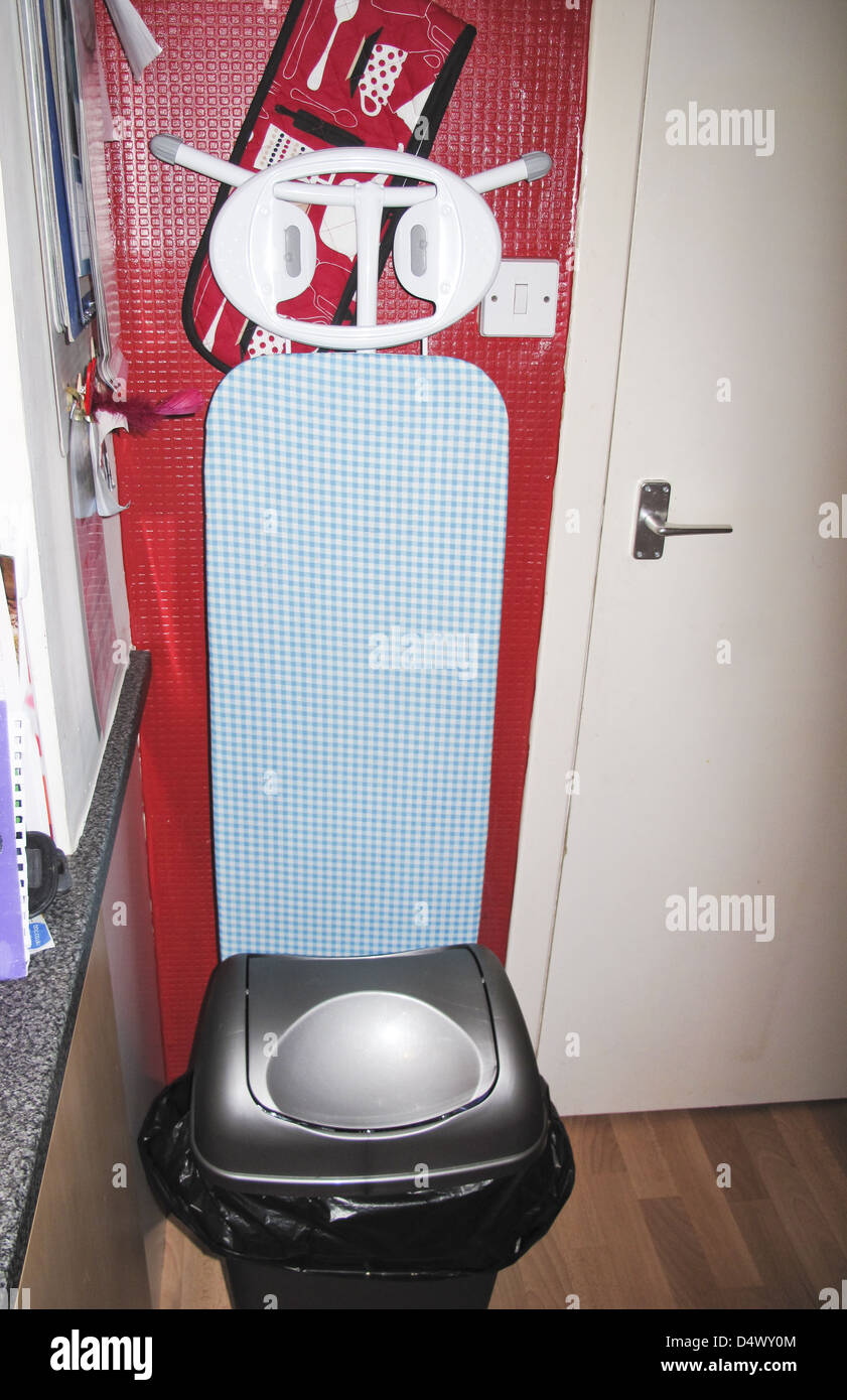 Cucina domestica scena con asse da stiro e forno guanto Foto Stock