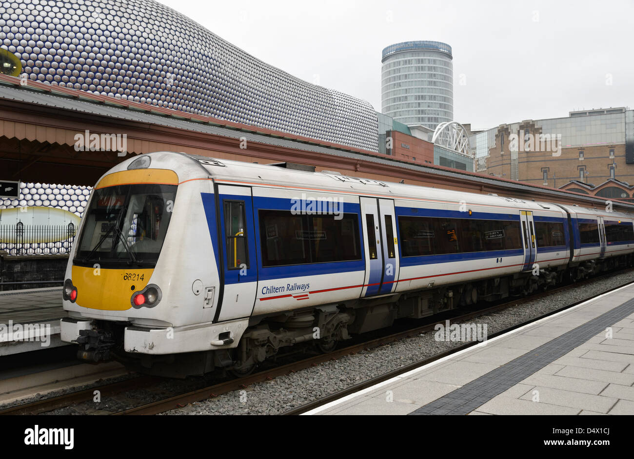 Un Chiltern Railways treno a Moor Street Station in Birmingham con locale landmarkthe Bullring e alla rotonda in background Foto Stock