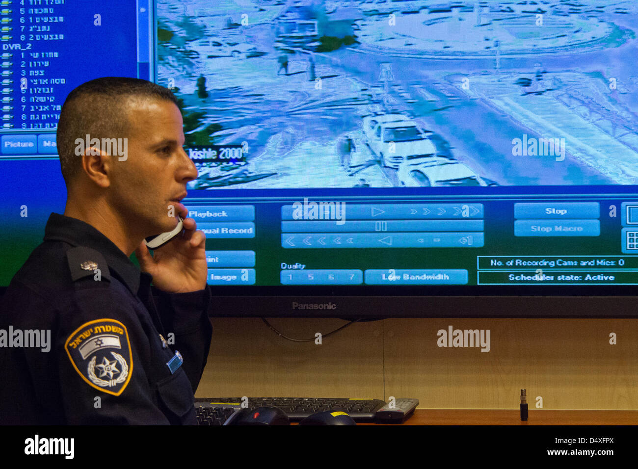 Un funzionario di polizia sta davanti a un grande schermo video sporgente originato dalla porta di Damasco a Gerusalemme come aree sensibili e le relative attività vengono monitorate a livello nazionale durante il funzionamento e Command Center in Israele la Polizia Nazionale HQ. Gerusalemme, Israele. 20-Marzo-2013. Israele commissario di polizia, Yohanan Danino, conduce i last minute ispezioni in punti cruciali nel quadro di funzionamento dell'alleanza indistruttibile di poche ore prima di U.S. Il presidente Barack Obama è previsto l arrivo di una 48 Ore di visita ufficiale. Gerusalemme, Israele. 20-Marzo-2013. Foto Stock