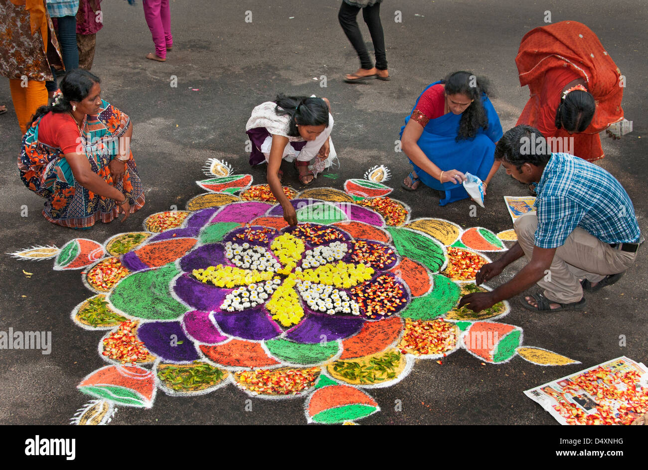 Chennai donna sta compiendo un Rangoli design con fiori in un Indiano street durante il festival indù di Sankranthi India India Foto Stock
