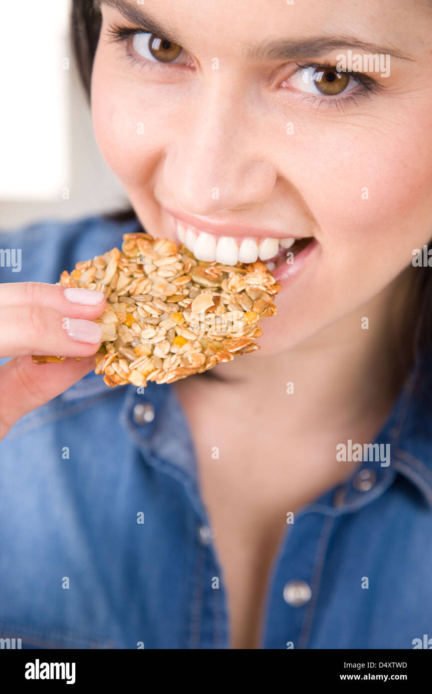 Donna di mangiare i fiocchi d'avena cookie Foto Stock