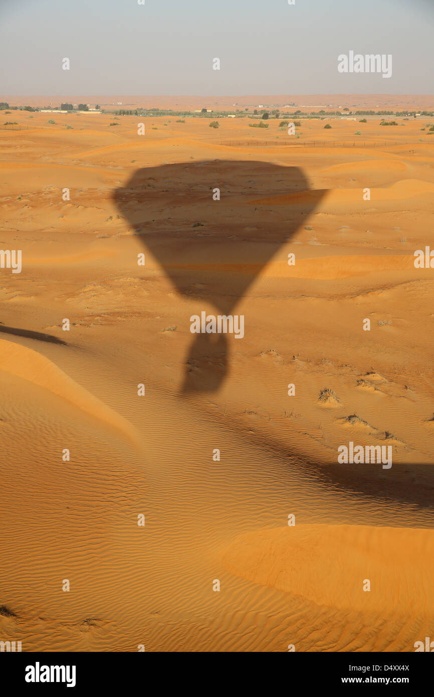 Ombra della mongolfiera oltre il deserto Arabico, Dubai, Emirati Arabi Uniti Foto Stock