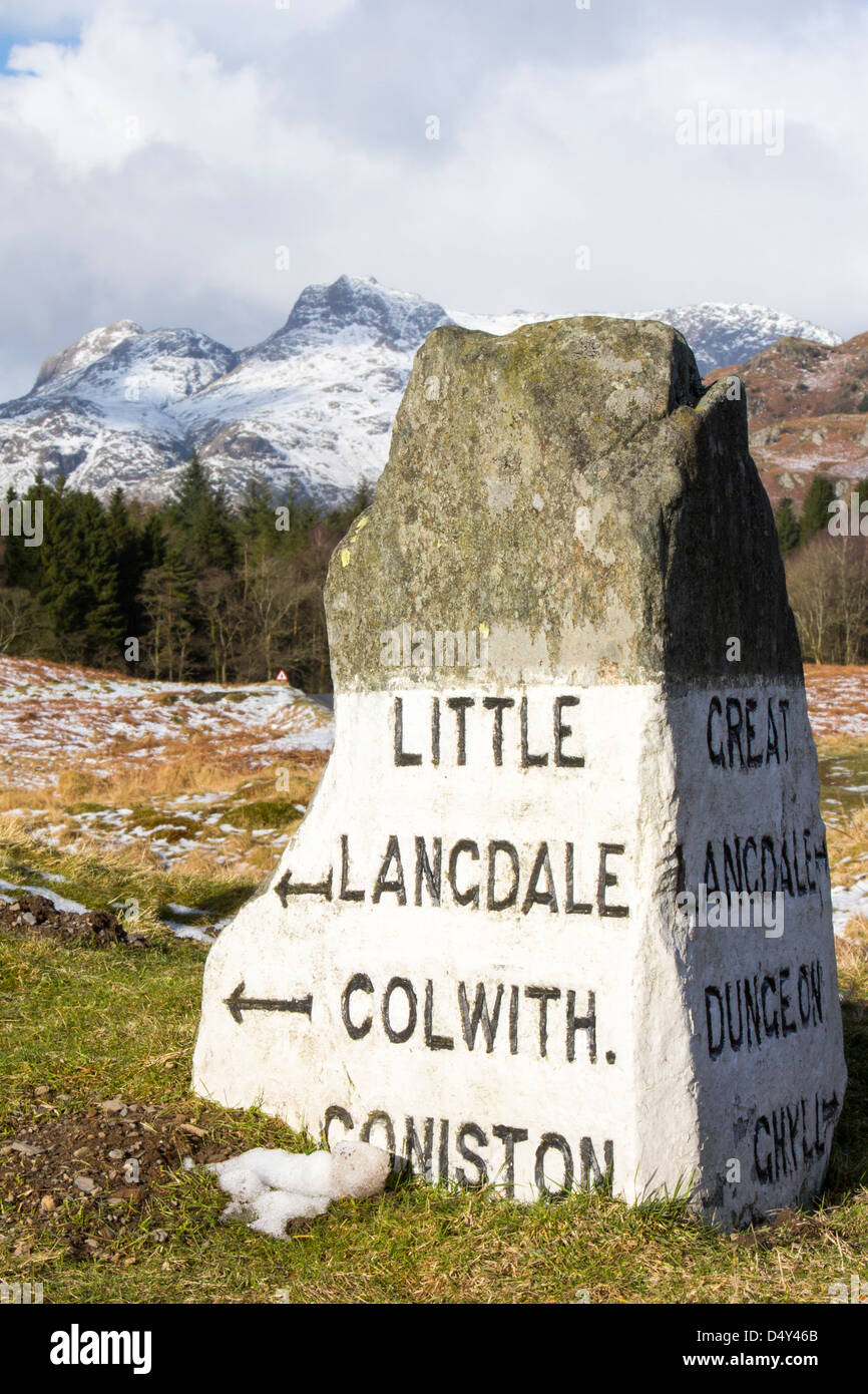 Un vecchio cartello stradale su Elterwater comune in The Langdale valley, guardando verso il Langdale pikes, Lake District, Regno Unito, Foto Stock