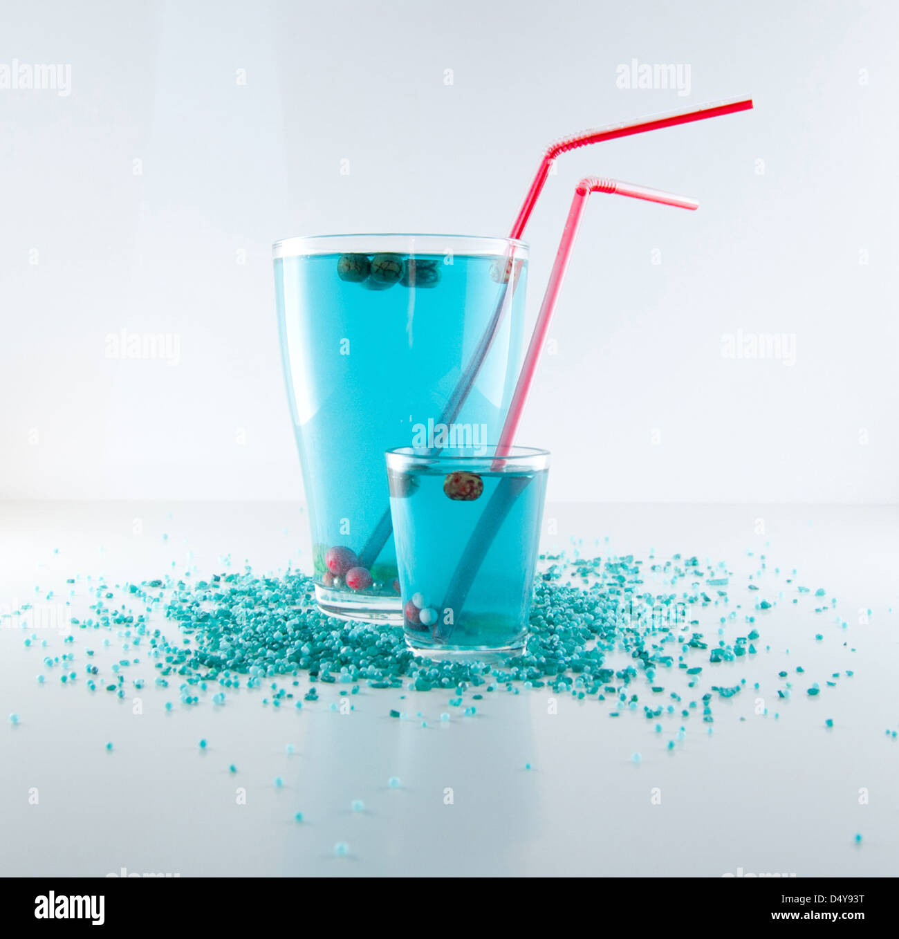 Due deliziosi cocktail blu in vetro con molti-perline colorate di rosso e puff Foto Stock