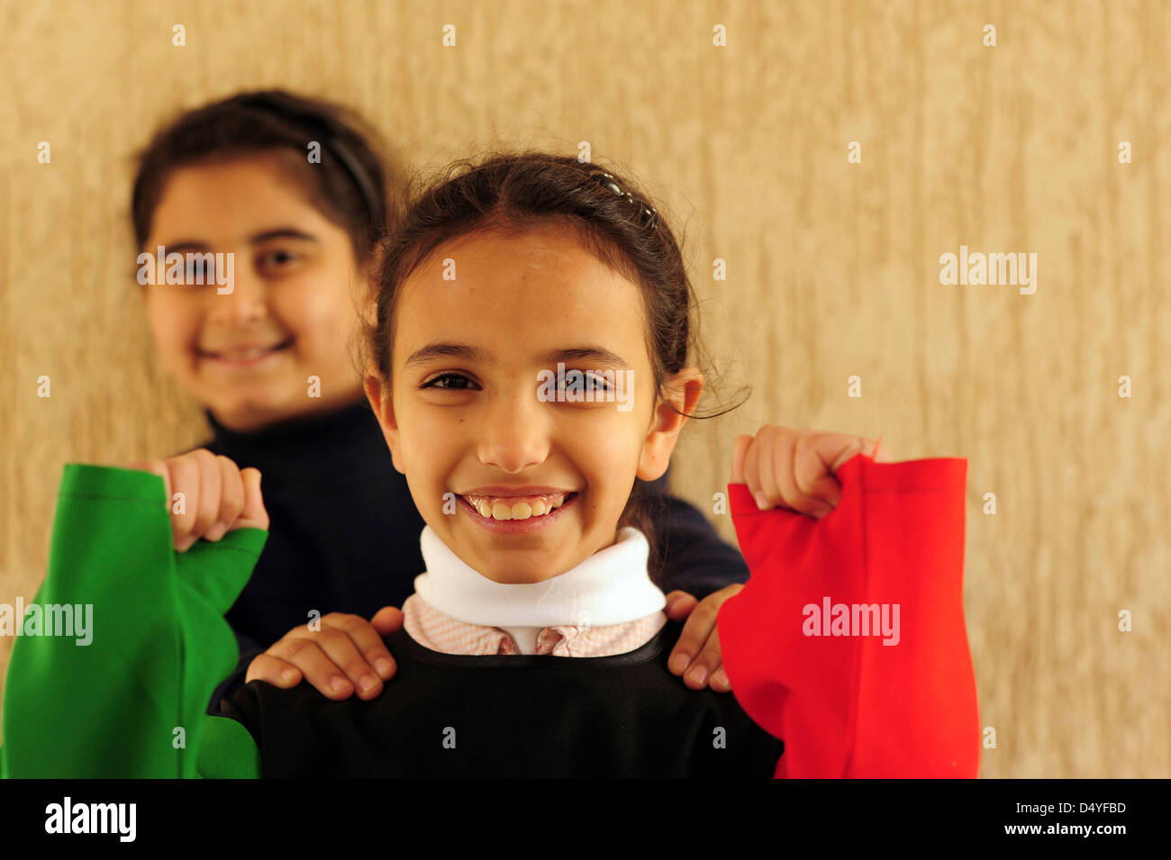Il Kuwait Kuwait City, di 2 ragazze sorridenti mascherate con bandiera kuwaitiana. (MR) Foto Stock