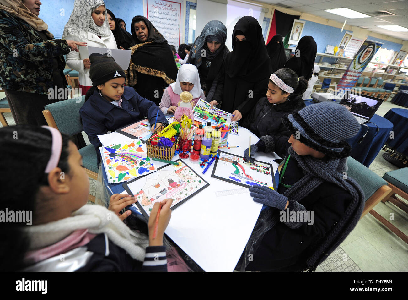Il Kuwait Kuwait City, disegno attività in aula con la supervisione degli insegnanti con il burqa. (MR) Foto Stock