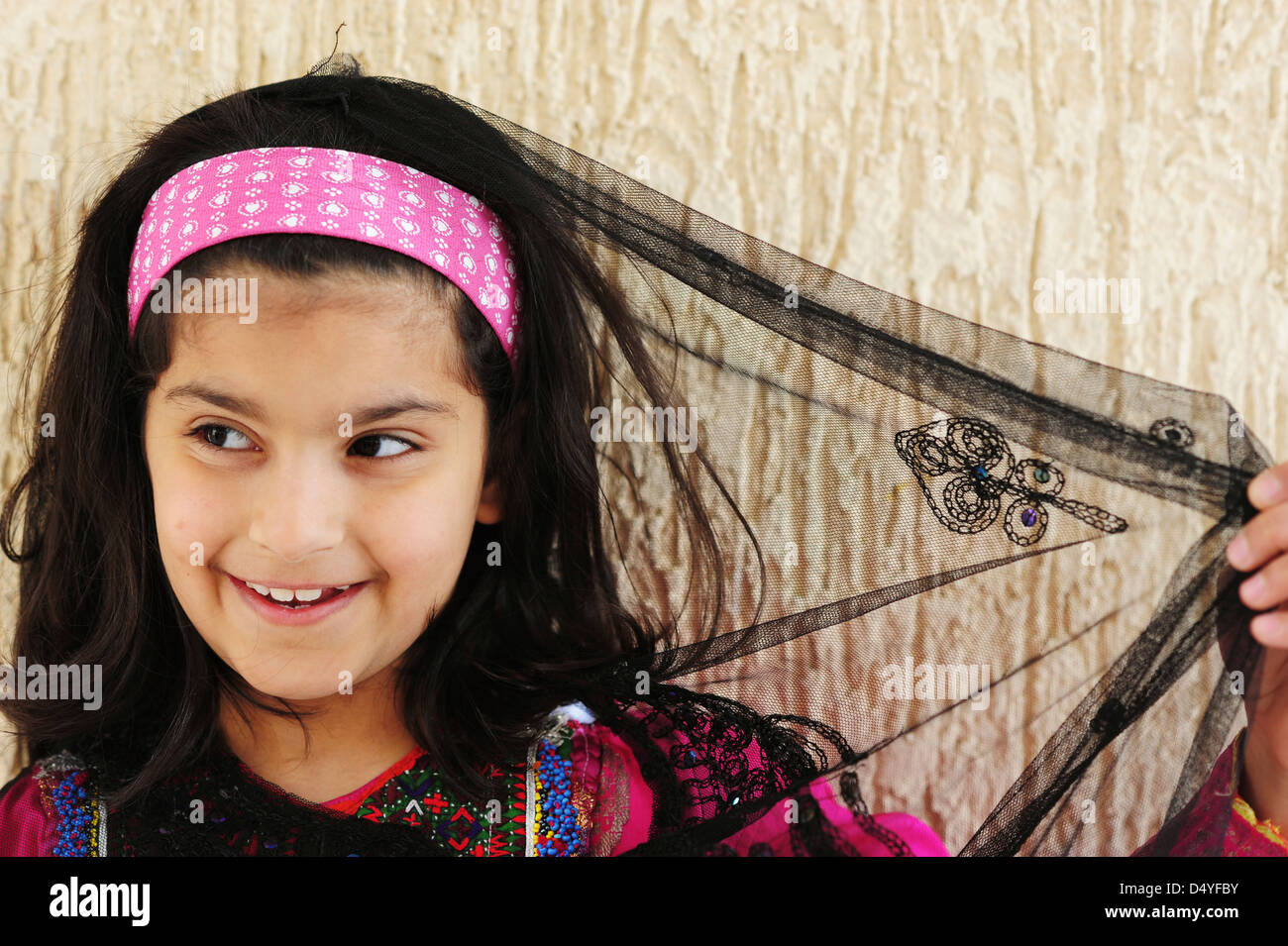 Il Kuwait Kuwait City, del Kuwait sorridente ragazza in abito tradizionale con luce velo. (MR) Foto Stock
