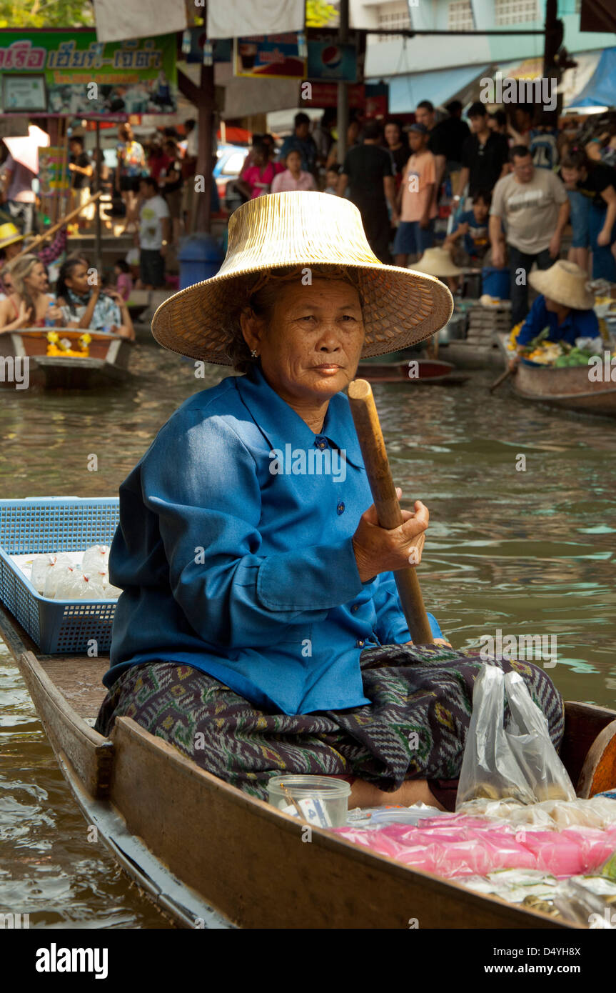 Thailandia, Mercato Galleggiante di Damnoen Saduak. Fornitore di donna, vendono spuntini e produrre da longboats lungo i corsi d'acqua. Foto Stock