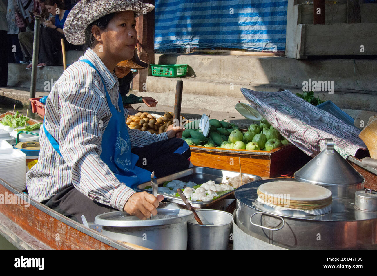 Thailandia, Mercato Galleggiante di Damnoen Saduak. Fornitore locale in barca sul canale vendono spuntini lungo i corsi d'acqua. Foto Stock