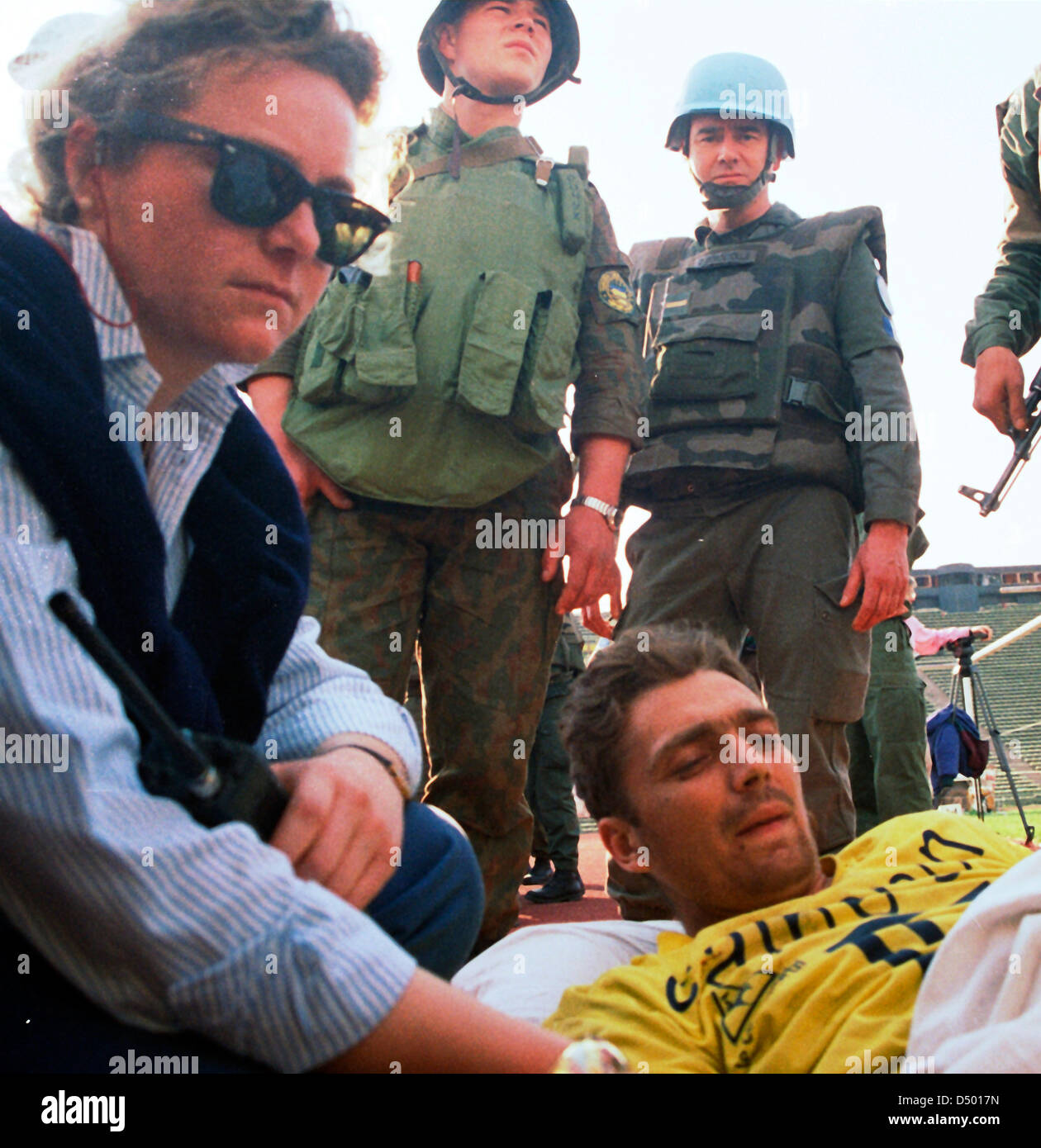 Un manovale, lungo con forza di protezione delle Nazioni Unite (UNPROFOR) soldati, comfort bosniaco uomo ferito durante l'assedio di Gorazde temporanea di un impianto di medivac allo stadio Olimpico di Sarajevo, Bosnia, lunedì, 4 aprile 1994. Foto Stock