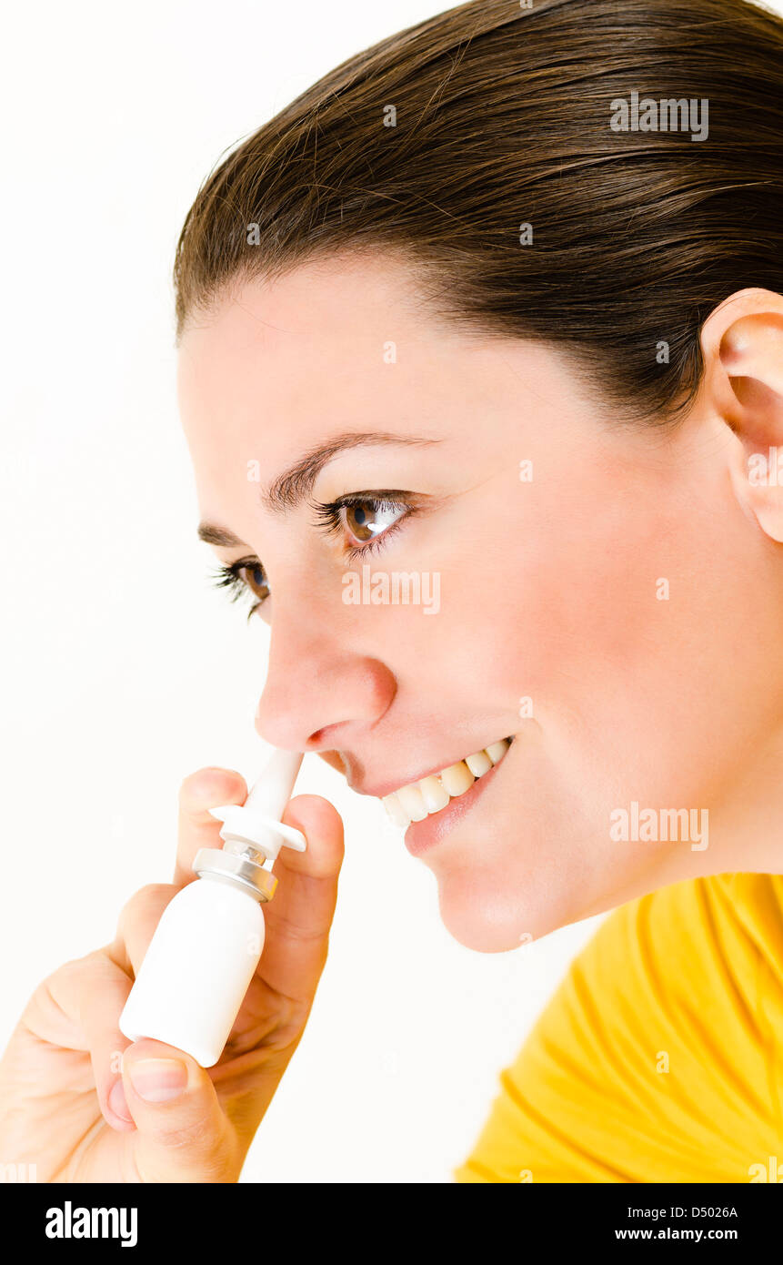 Una donna felice utilizzando uno spray nasale Foto Stock