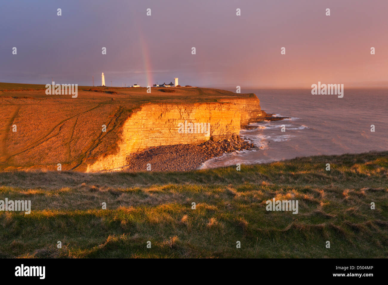 Rainbow supera Nash punto al tramonto. Glamorgan Heritage Coast. Vale of Glamorgan. Il Galles. Regno Unito. Foto Stock