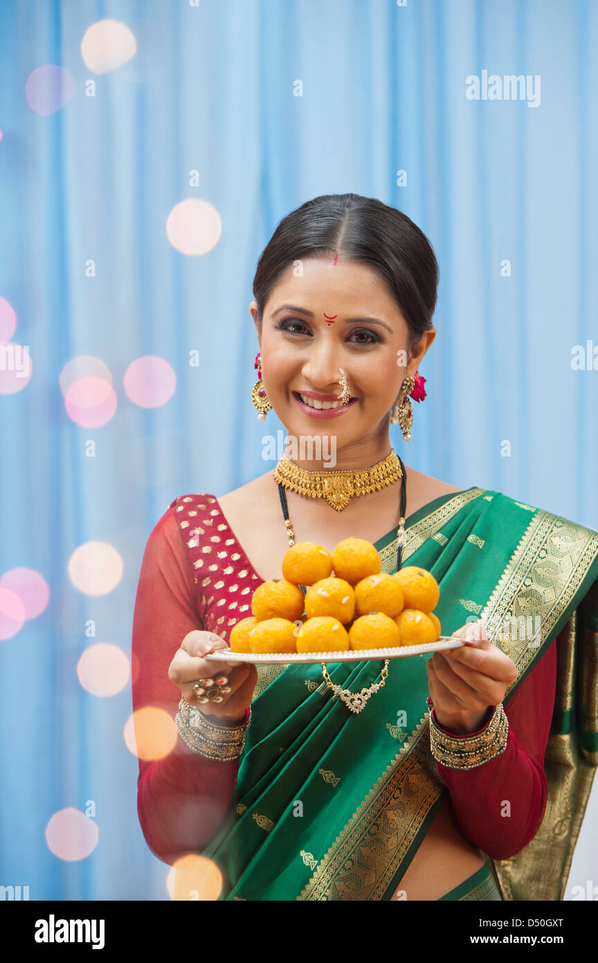 Donna Maharashtrian tenendo un piatto di laddoo a Ganesh Chaturthi Foto Stock